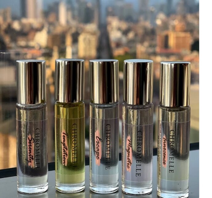 The five Chromelle perfume oils lined up against a city skyline